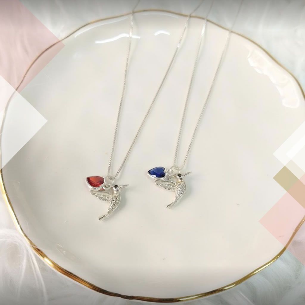 Cadena con dije colibrí y corazón cristal rojo o azul con argollitas en juego. Plata 925